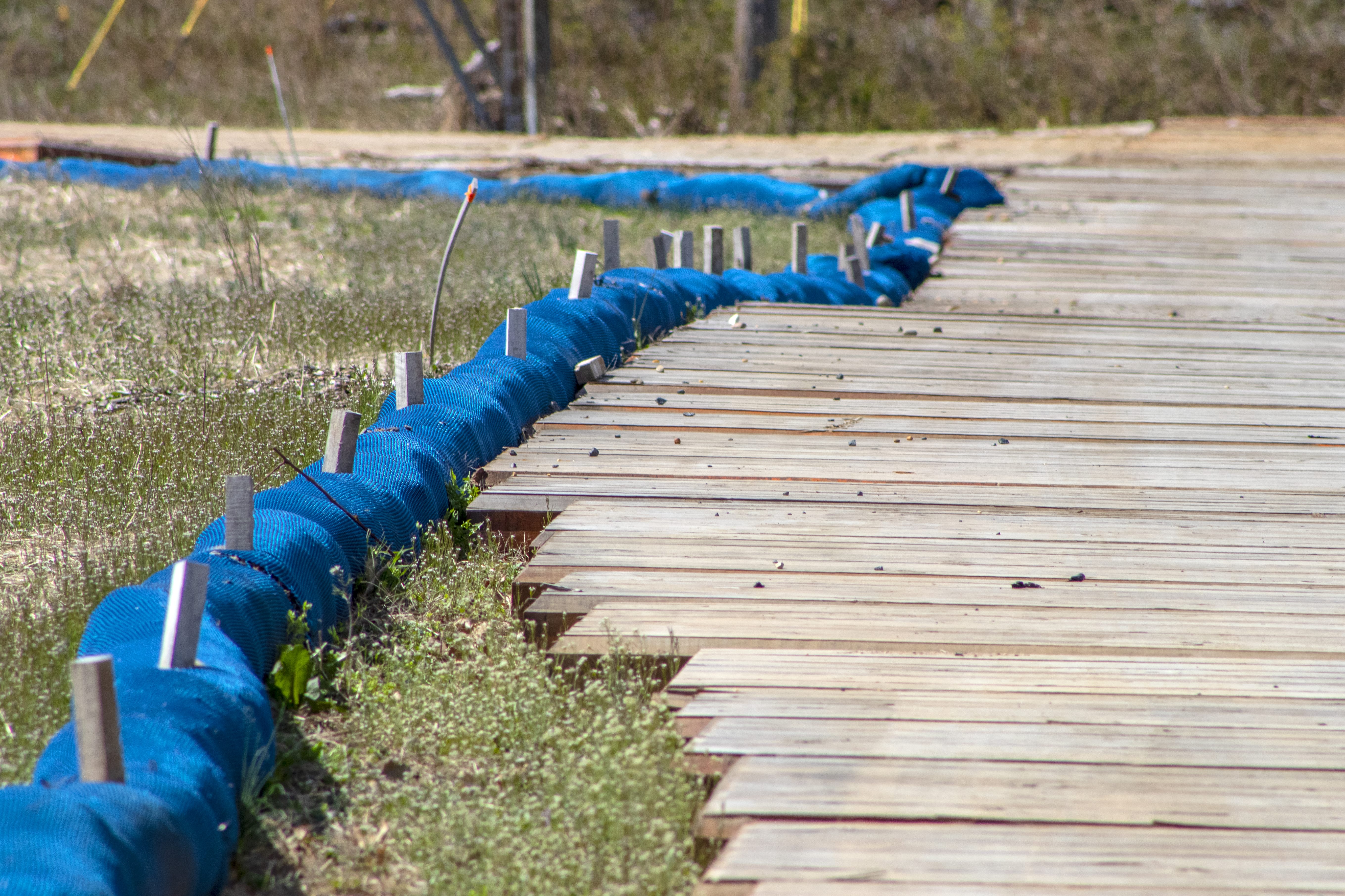 Straw wattle tubes sit outside a TerraLam mat road on a PGE&G in New Jersey